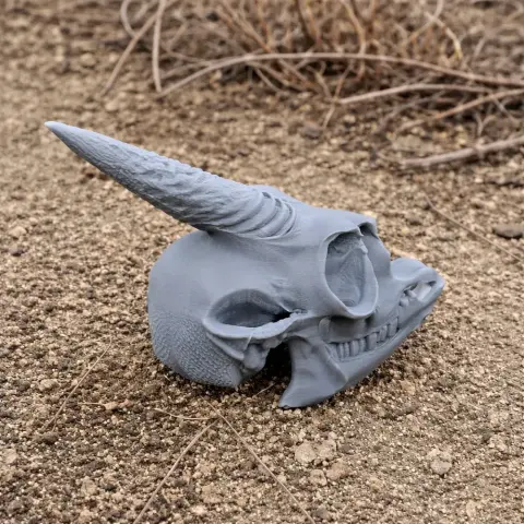A detailed 3D-printed replica of a dik-dik skull with one long horn, set on a textured surface.
