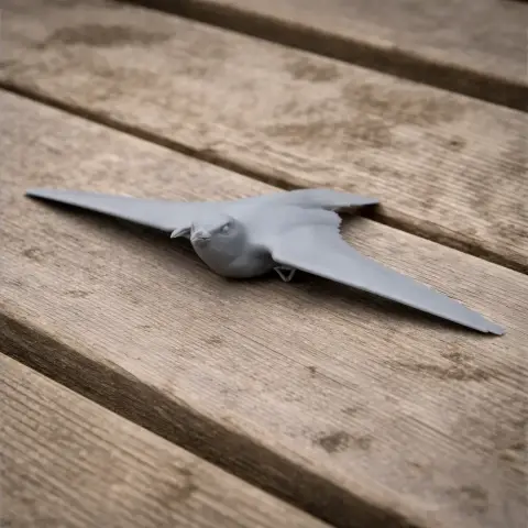 3D model of a prehistoric bird with outstretched wings on a wooden surface.