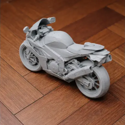 3D printed model of a sport motorcycle on a wooden floor, showcasing intricate details and design.