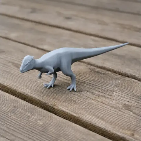 3D printed model of a Prenocephale dinosaur, standing on a wooden surface.