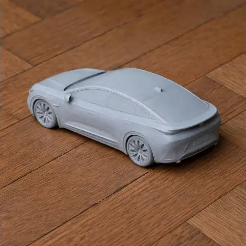 3D-printed model of a sleek, futuristic car on a wooden surface.