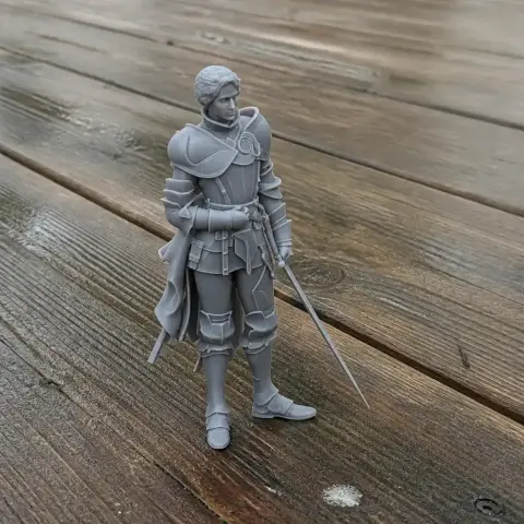 3D printed model of a knight in armor with a sword, standing on a wooden surface.