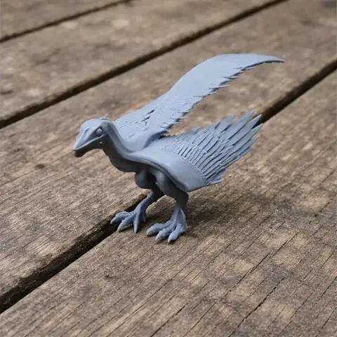 A gray 3D-printed model of a protoavis with outstretched wings on a wooden surface.