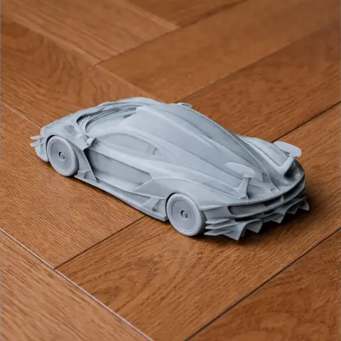 3D-printed model of a sleek, futuristic sports car on a wooden surface.
