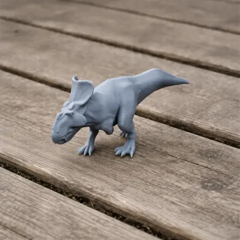 A gray 3D-printed Protoceratops model standing on a wooden surface.