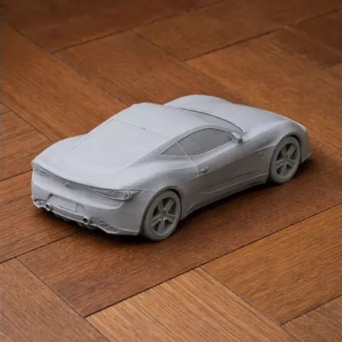 3D printed scale model of a sleek sports car on a wooden surface.