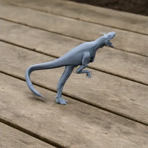 A small 3D printed model of a Raptorex dinosaur posed on a wooden surface.