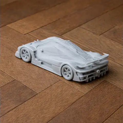 Futuristic race car model with sleek design on wooden surface, optimized for 3D printing.