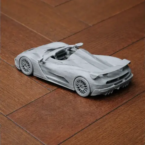 A detailed 3D printed model of a sleek sports car with aerodynamic design features.