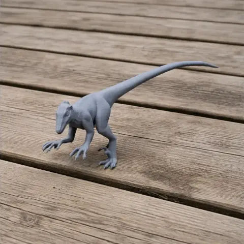 3D printed model of a small dinosaur with a long tail and sharp claws on a wooden surface.