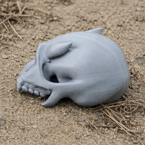 A 3D-printed Eomellivora skull replica rests on sandy ground with scattered dry grass.