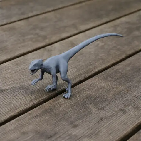 Gray 3D-printed model of a Saurornithoides dinosaur on a wooden surface.