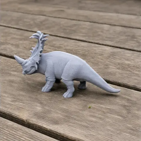 A 3D printed model of a Sinoceratops dinosaur with detailed horns on wooden surface.