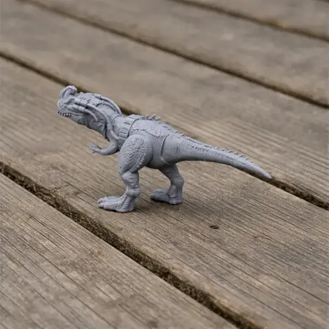 Gray 3D-printed Sinotyrannus dinosaur model on a wooden surface.