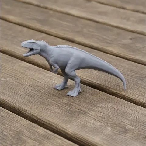 Gray 3D-printed model of a Sinraptor dinosaur on a wooden surface.