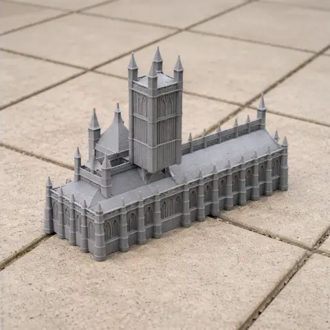 Gray 3D-printed model of a cathedral with tall spires, placed on a tiled surface.