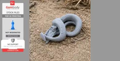 A 3D-printed goat skull model with intricate curved horns, resting on a sandy surface.