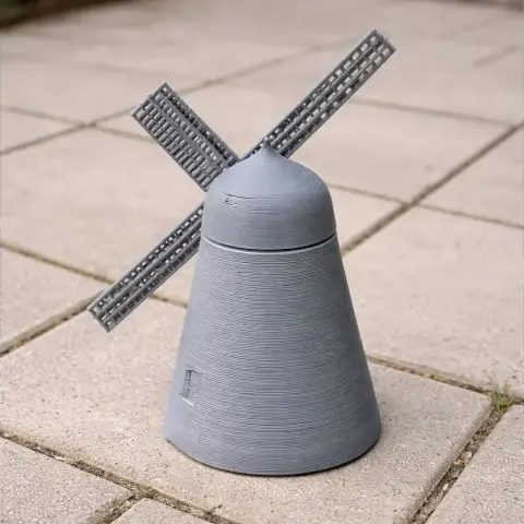3D printed model of a gray windmill with four blades on a tiled surface.