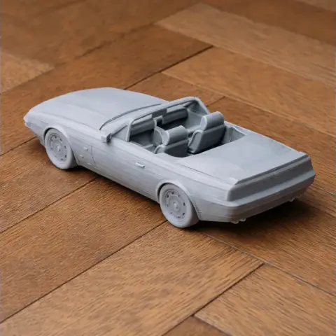 3D printed scale model of an Aston Martin V8 Zagato convertible on a wooden surface.