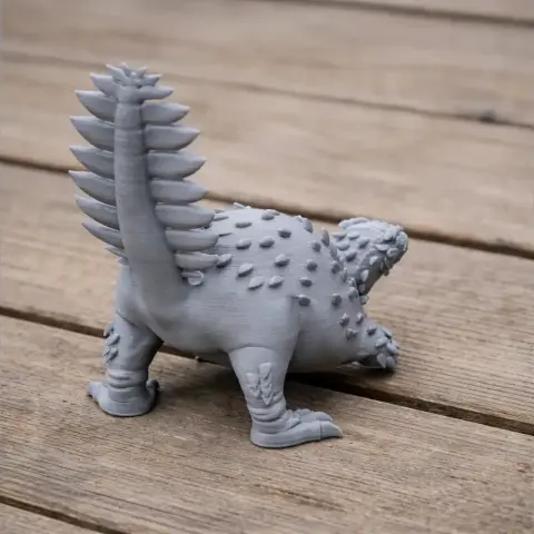 A 3D-printed Stegouros model with spiky back and tail, placed on a wooden surface.
