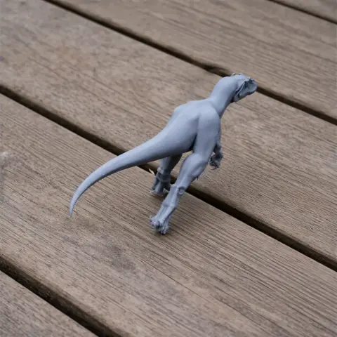 Gray Szechuanosaurus 3D print model on wooden surface, viewed from behind.