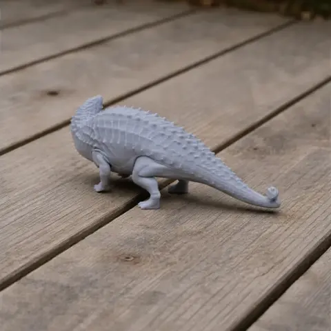 3D printed model of a Talarurus, a spiky prehistoric dinosaur, on a wooden surface.