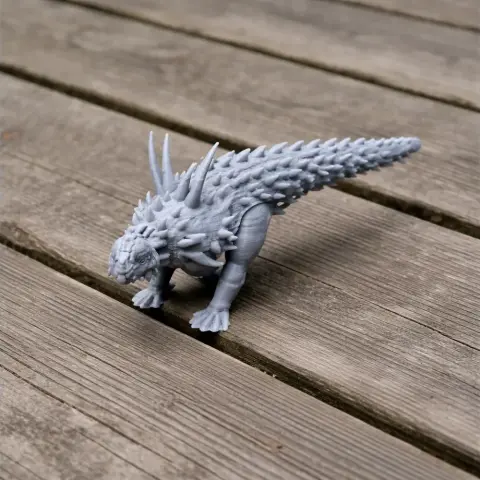 3D printed model of a spiky, prehistoric animal with a long tail, placed on wooden planks.
