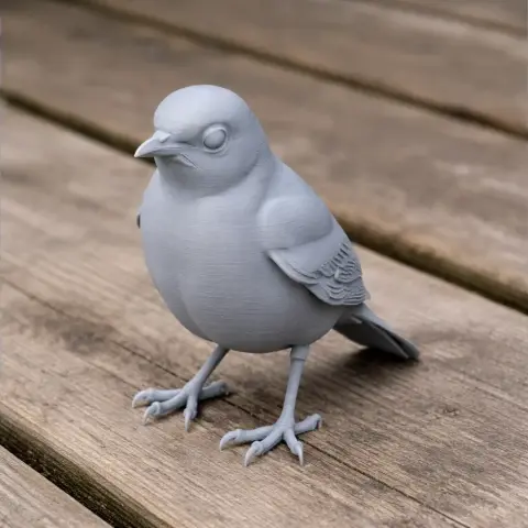 Gray 3D-printed thrush model with detailed feathers, perched on a wooden surface.