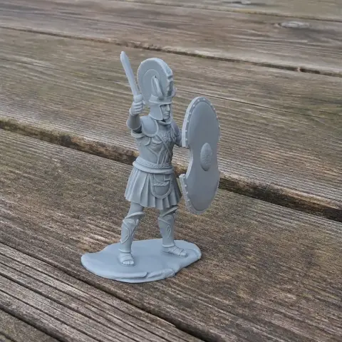 3D model of a Spartan warrior with helmet, shield, and raised sword, standing on a textured base.