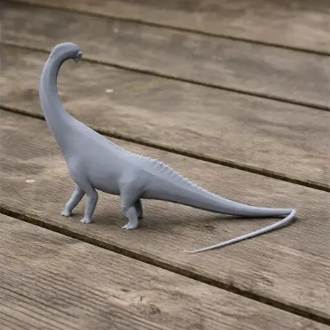 Gray 3D-printed model of a Titanosaurus, a long-necked prehistoric dinosaur, on a wooden surface.