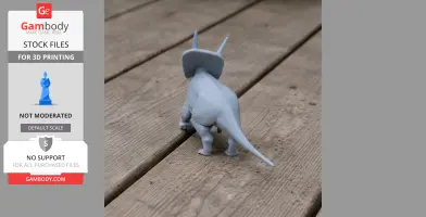 Gray 3D-printed Torosaurus model on a wooden surface, showcasing its back and horns.