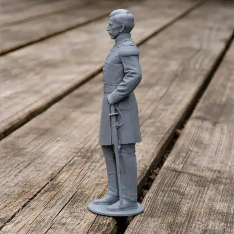 3D-printed figure of a Civil War soldier in uniform, standing at attention on a wooden surface.