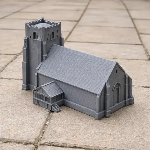 3D printed model of a medieval church with a tower and detailed roof on a tiled surface.