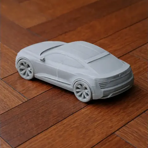 3D printed scale model of a sleek Audi vehicle on a wooden floor.