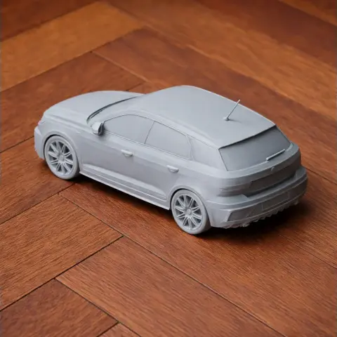A 3D-printed scale model of an Audi A1 on a wooden floor.