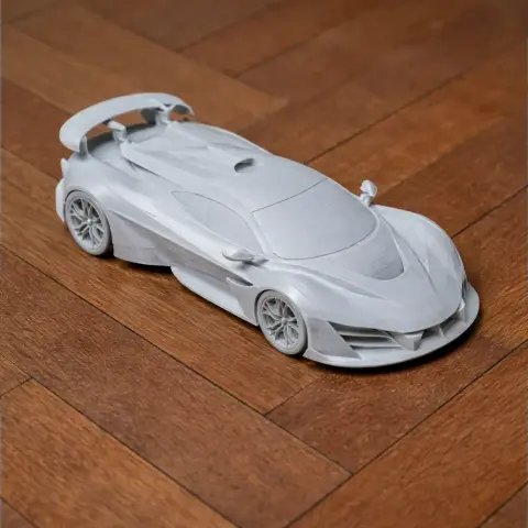 A detailed 3D-printed model of an Aston Martin Valhalla car on a wooden surface.