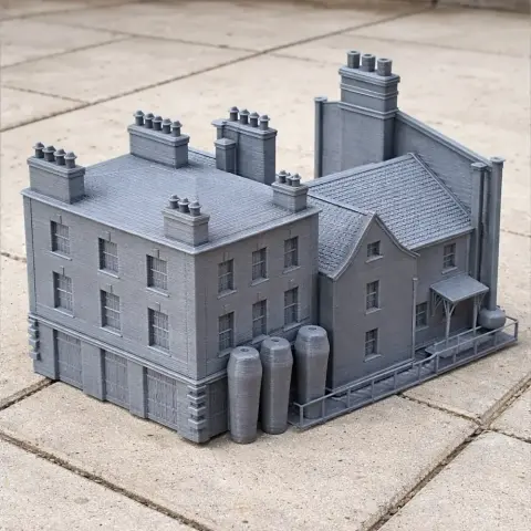 A detailed 3D-printed model of a historic-style building with multiple chimneys and silos.