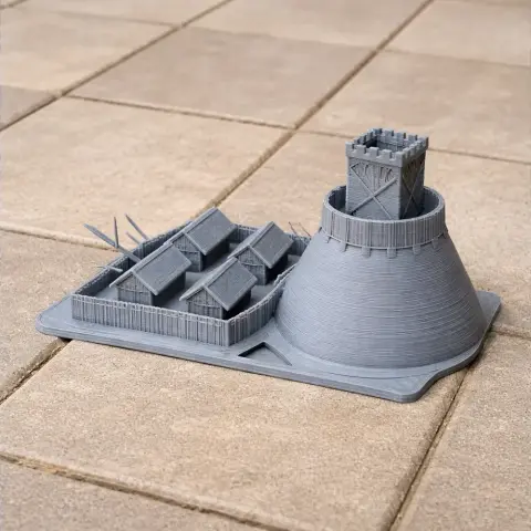 3D-printed motte-and-bailey castle model with a tower and houses on a tiled surface.