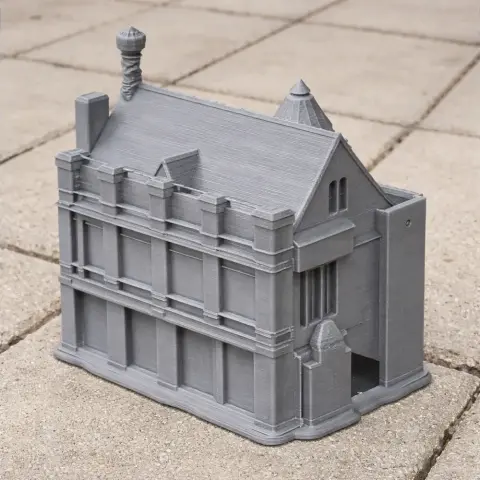 A detailed 3D-printed gray model of a multi-story castle with turrets and intricate architectural features.