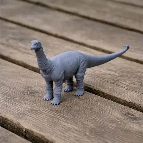 A gray 3D-printed model of a Vulcanodon dinosaur standing on a wooden surface.