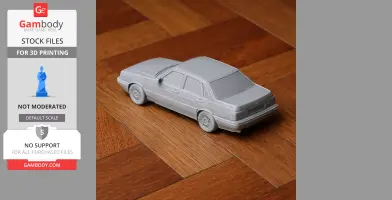 A 3D-printed model of an Audi 90 car in gray on a wooden surface.