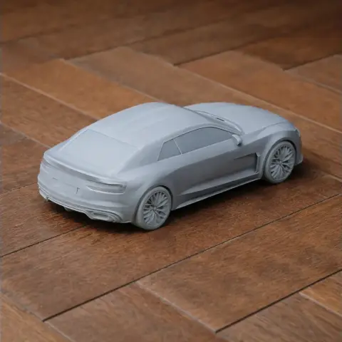 3D-printed model of a sleek Audi quattro concept car on a wooden surface.