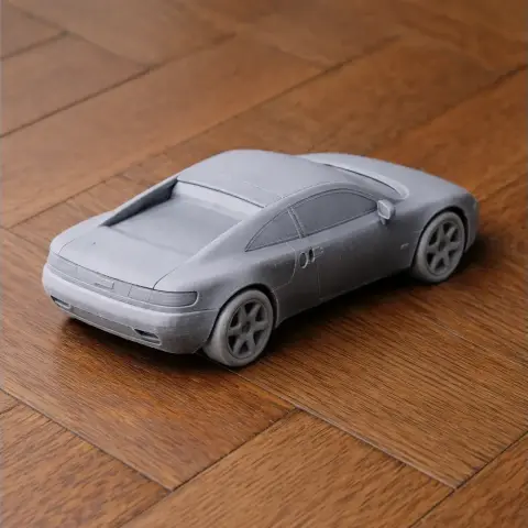 Gray 3D printed scale model of the Audi Quattro Spyder Concept on a wooden surface.