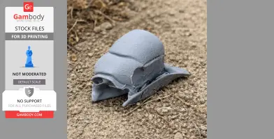 A 3D-printed helmeted hornbill skull replica lying on textured ground.