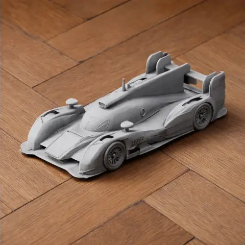 3D printed model of an Audi R18 race car on a wooden surface.