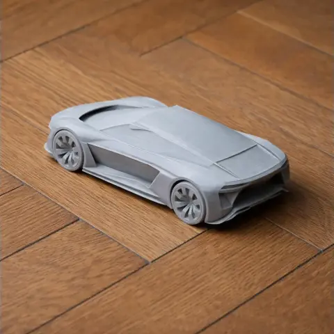 A sleek, gray 3D-printed model of an Audi R8 on a wooden floor.
