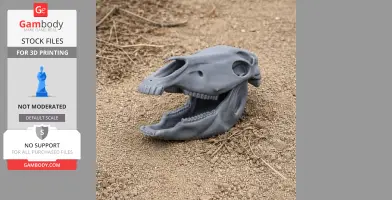 A gray 3D printed horse skull replica resting on sandy ground.
