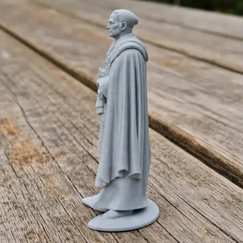 3D-printed figure of a historical warrior in a cape, standing on a round base.