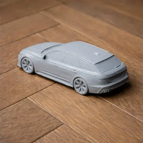 Gray 3D-printed model of an Audi RS6 car on a wooden surface.