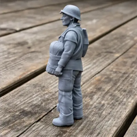 3D-printed WWII soldier figure in uniform, holding a bundle, standing on a wooden surface.